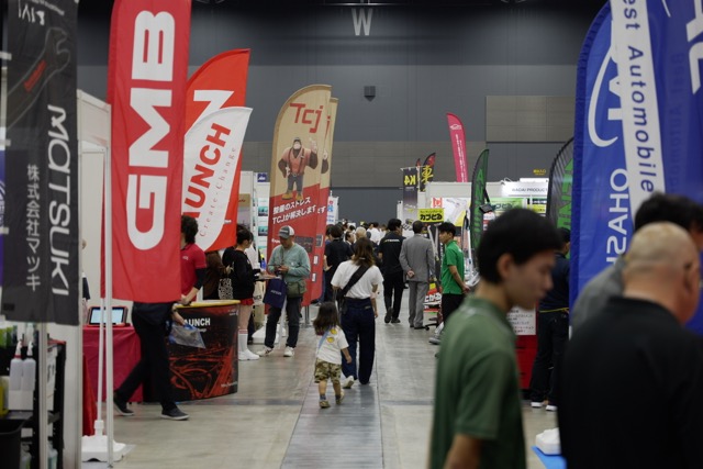マリンメッセ福岡の展示会で、各社のブースが並ぶ通路を来場者が行き交う様子